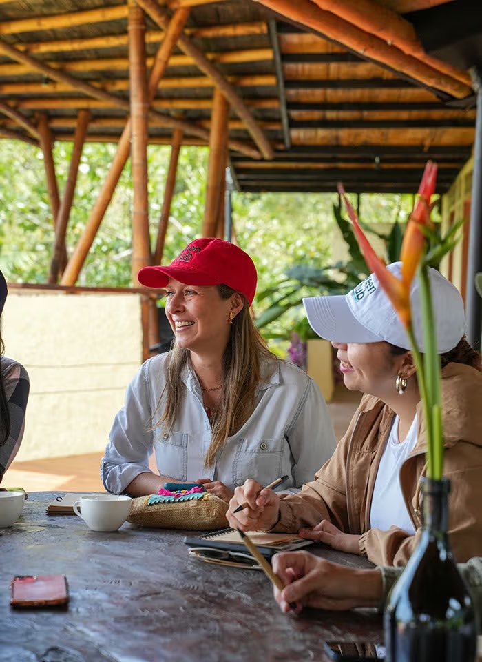 Attendees taking notes over coffee under the pavilion