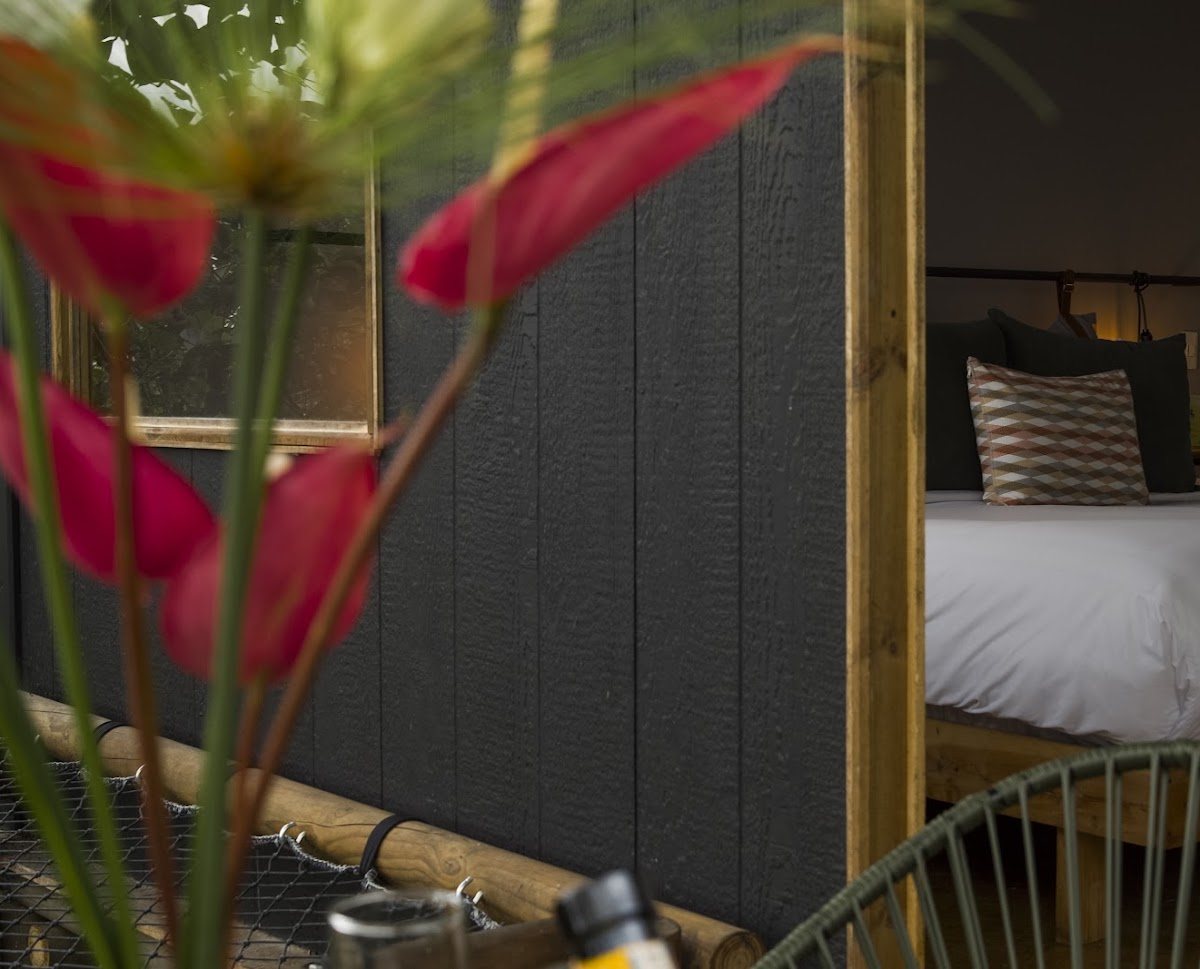The bed glimpsed through the room door, framed by flowers